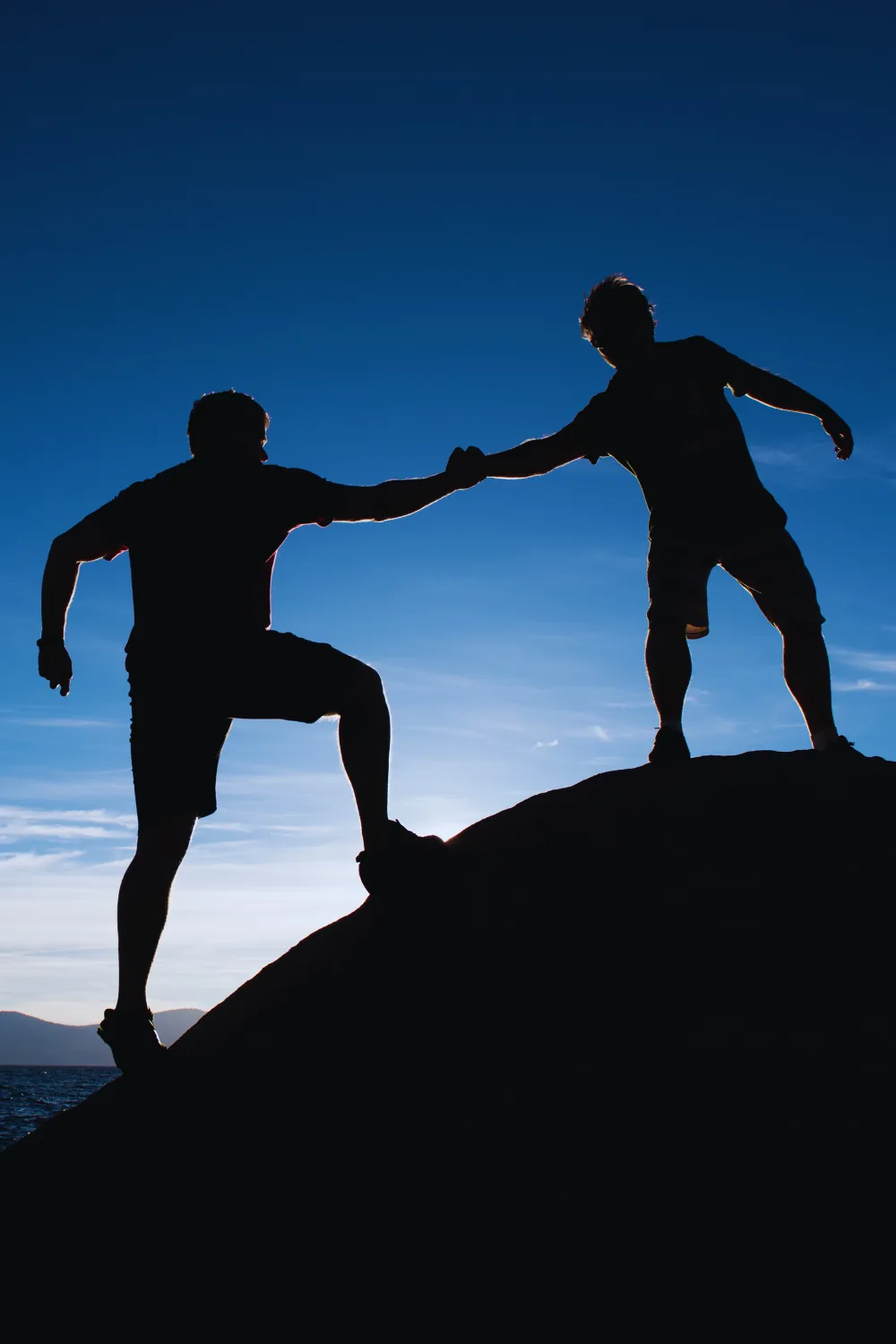 A person helping another up a hill, from the Boss Mortgage image library